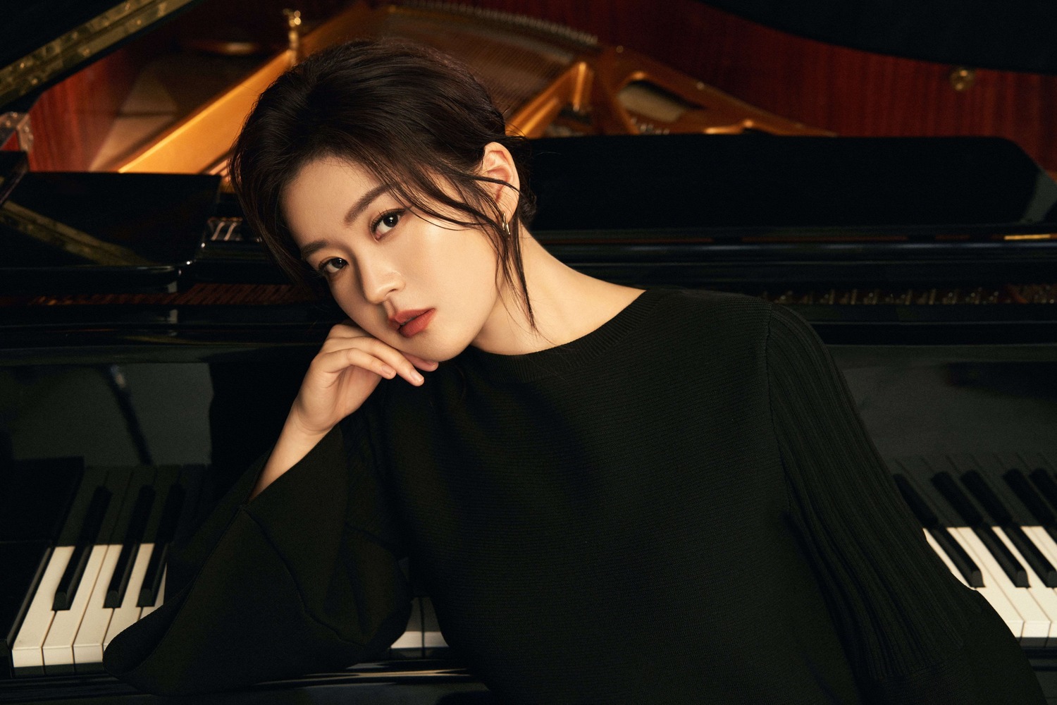 Ming Hu beside a grand piano